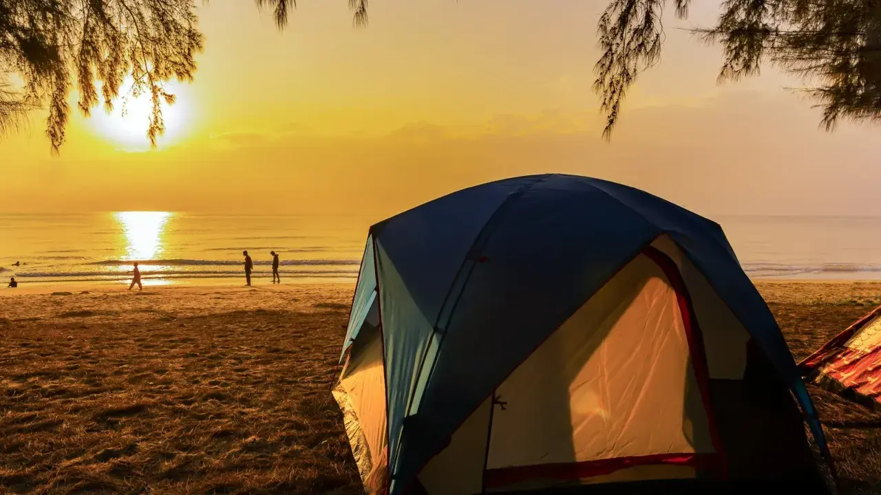 Namiot na plaży o zachodzie słońca. Idealne miejsce na najlepsze pola namiotowe nad morzem.