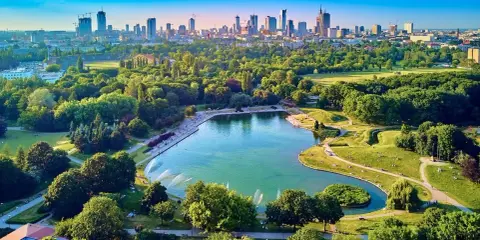 Piękny park z jeziorem i fontannami, idealne miejsce na relaks. W tle widać panoramę Warszawy, co czyni to jedno z fajnych miejsc w Warszawie.
