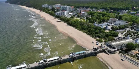 Miejscowości nad Bałtykiem na Pomorzu Zachodnim: plaża, molo, hotele i las.