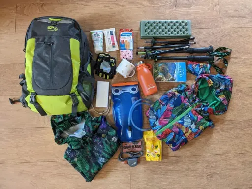 Plecak, kijki trekkingowe, bukłak, kurtka i inne akcesoria gotowe na wyjazd w góry.