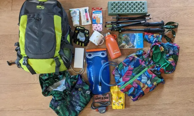 Plecak, kijki trekkingowe, bukłak, kurtka i inne akcesoria gotowe na wyjazd w góry.