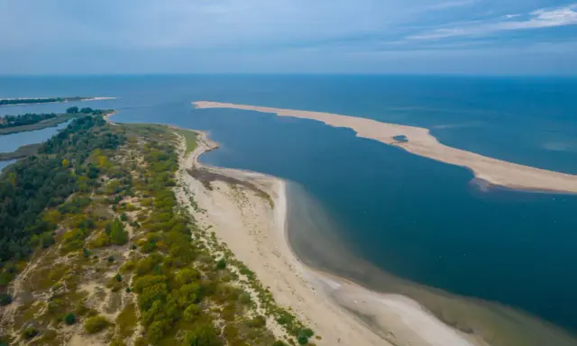 Piaszczysta mierzeja z zielenią i błękitną wodą – jedno z najpiękniejszych miejsc nad polskim morzem.