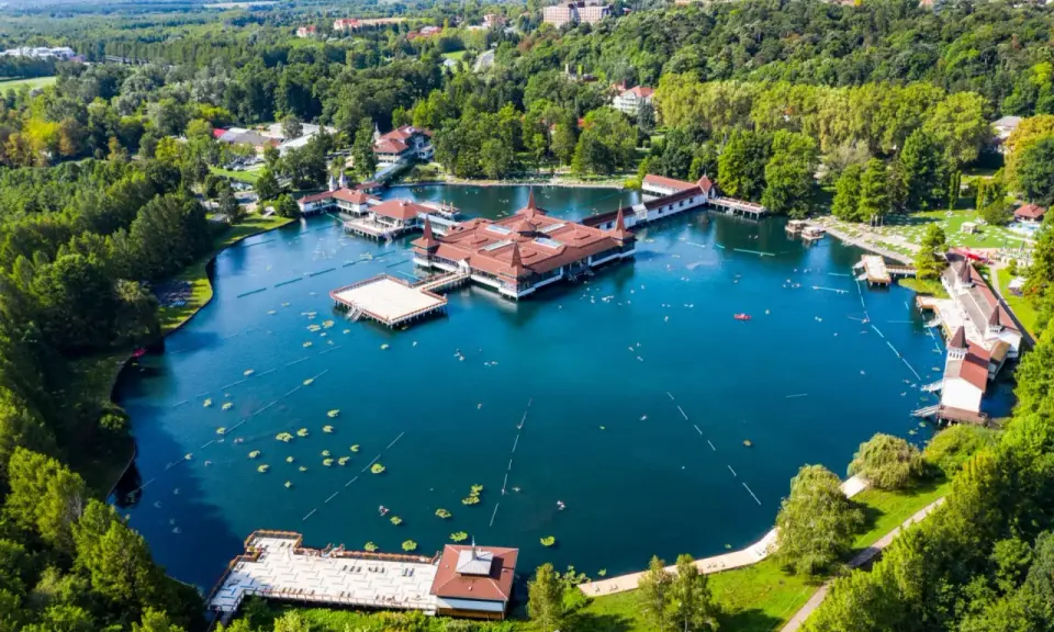 Termalne jezioro z pływającymi budynkami i ludźmi kąpiącymi się w wodzie. To jedno z najpiękniejszych miejsc nad Balatonem.