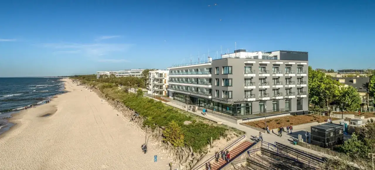 Nowoczesny hotel nad morzem, idealny pomysł na wyjazd urodzinowy. Piękna plaża i błękitne niebo.