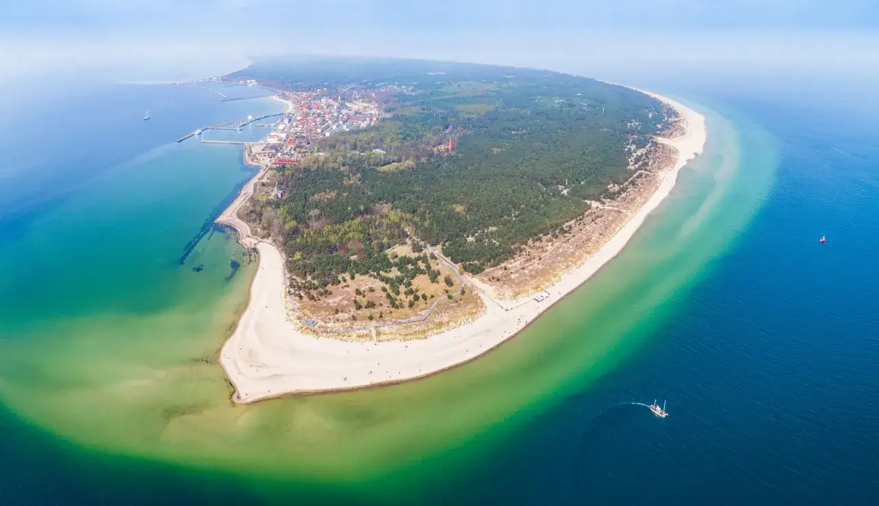 Malowniczy widok na Półwysep Helski, idealny na trasę rowerową Gdańsk Hel. Woda mieni się odcieniami turkusu i granatu, a plaże zapraszają do odpoczynku.